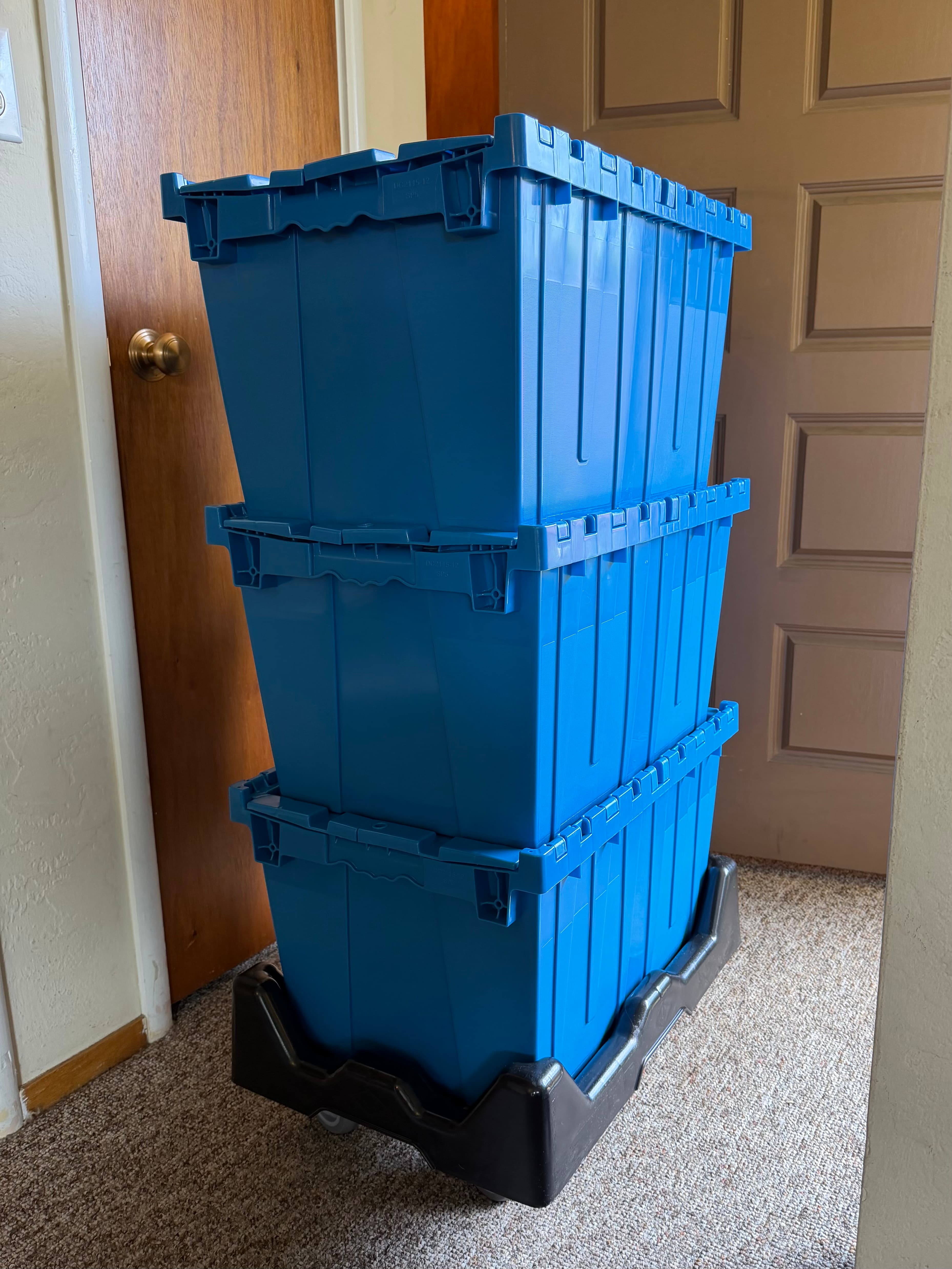 A stack of blue Cruz Totes on a dolly at the front door
