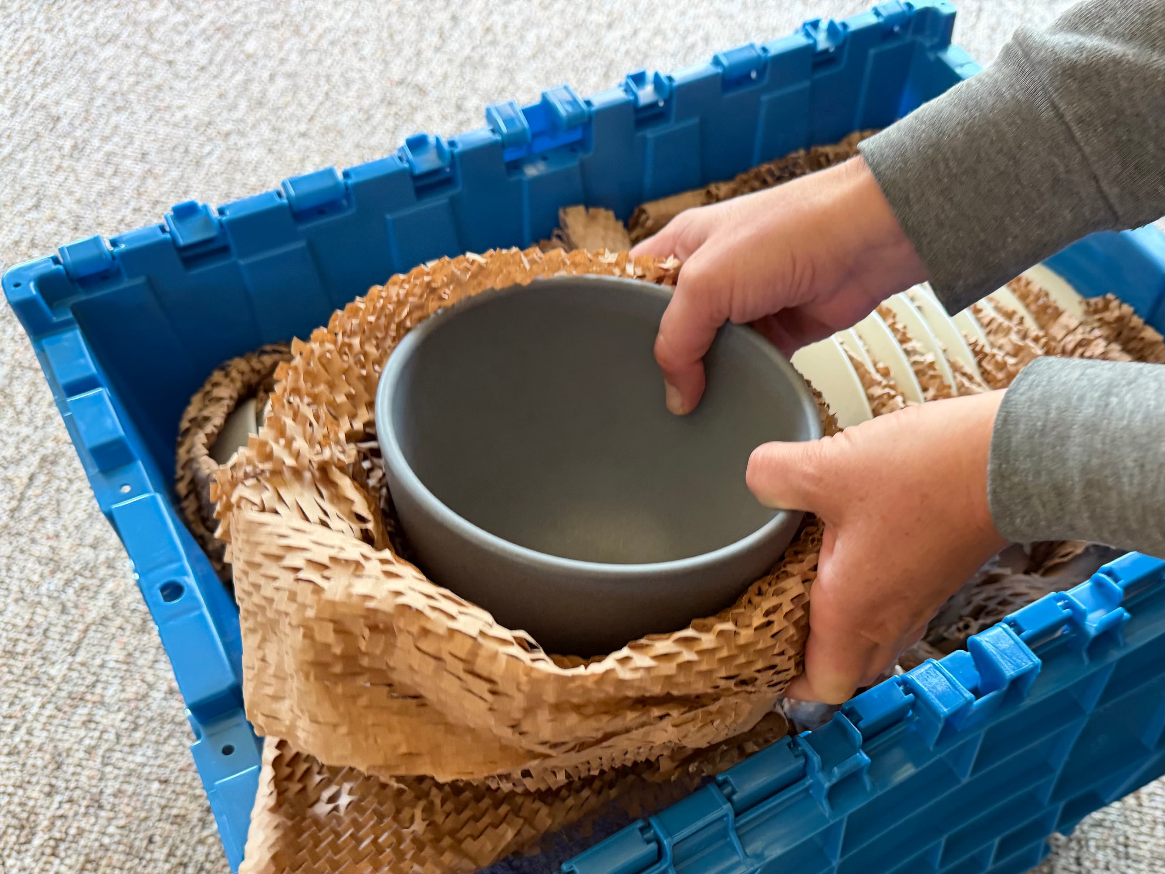 A mover unpacking blue Cruz Totes totes in a new home